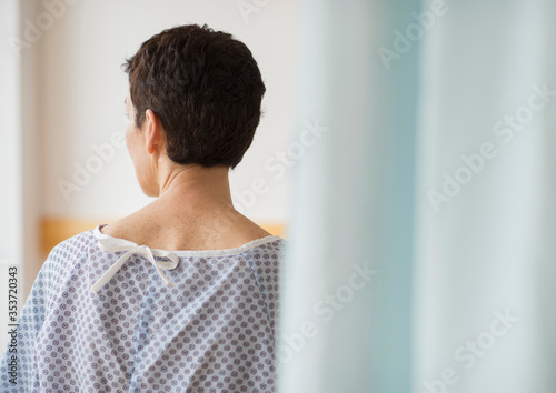 Rear view of senior woman wearing hospital gown photo