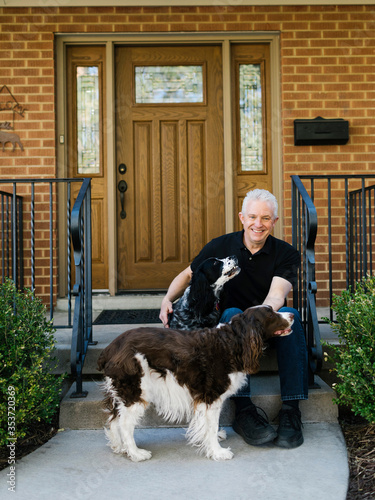 English springer spaniels and owner in front of house photo