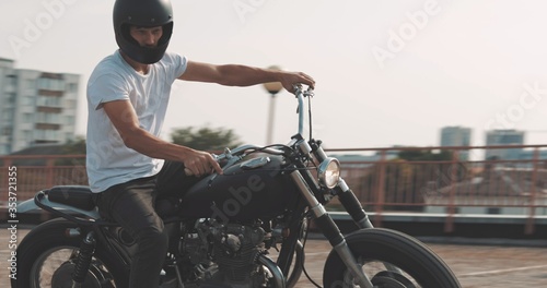Canvas Print Biker riding on motorcycle in parking lot