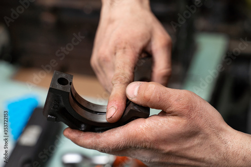 Car worker repair a pistons in autoservice. Piston defective checking. © KNV