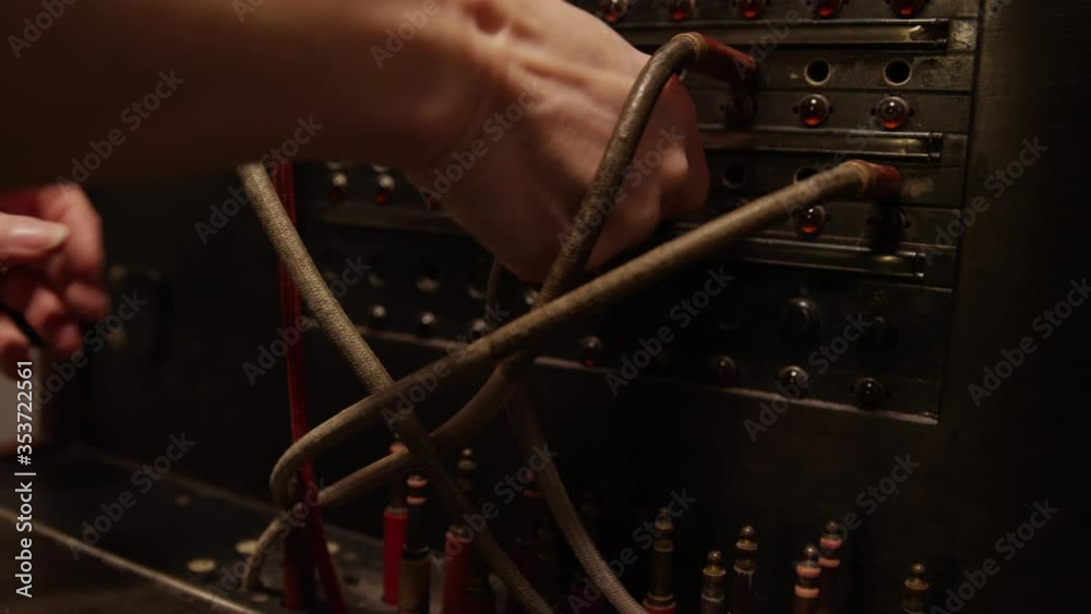 Close up of stressed out hands switching tangled telephone switchboard cables