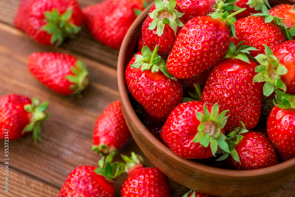 Fresh strawberries in a bowl on wooden table. Strawberry in a Bowl. Top view Fresh strawberries in a bowl on wooden table. Strawberry in a Bowl. Top view