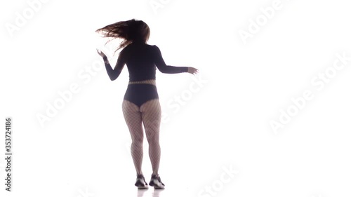 young beautiful girl dancer with long hair in fishnet tights and shorts dancing dancehall twerk, street modern dance, long shot, isolated