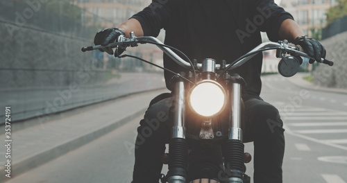 Fotografie, Obraz Biker riding on motorcycle in city