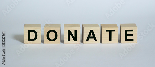 Donate written text on wooden cubes on a white background. Donation to the needy concept.