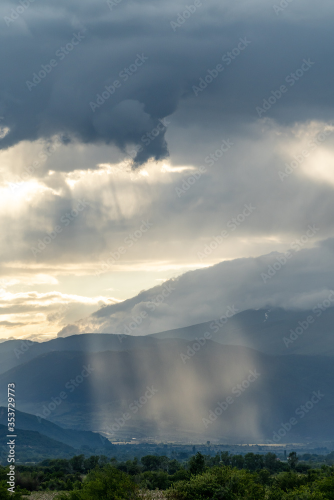 Sun rays lighting the ground through the clouds Sun rays lighting the ground through the clouds