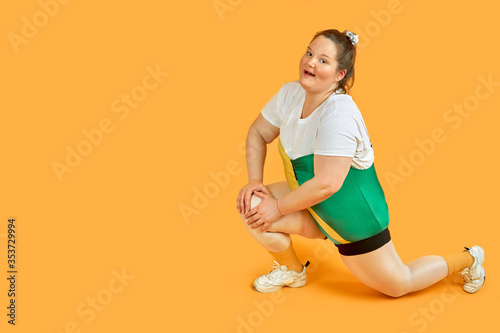Bright cheerful fat girl is engaged in sports and looks at the camera.