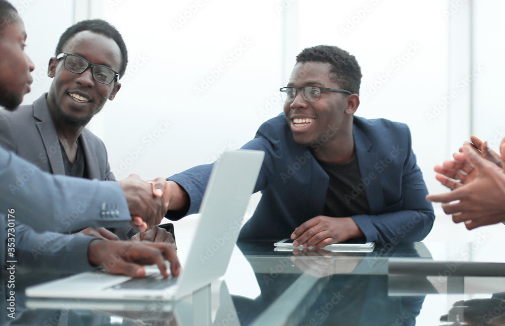 happy business partners shaking hands at meeting in the office. happy business partners shaking hands at meeting in the office.