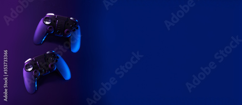 Black gamepads on black background in neon lights. photo