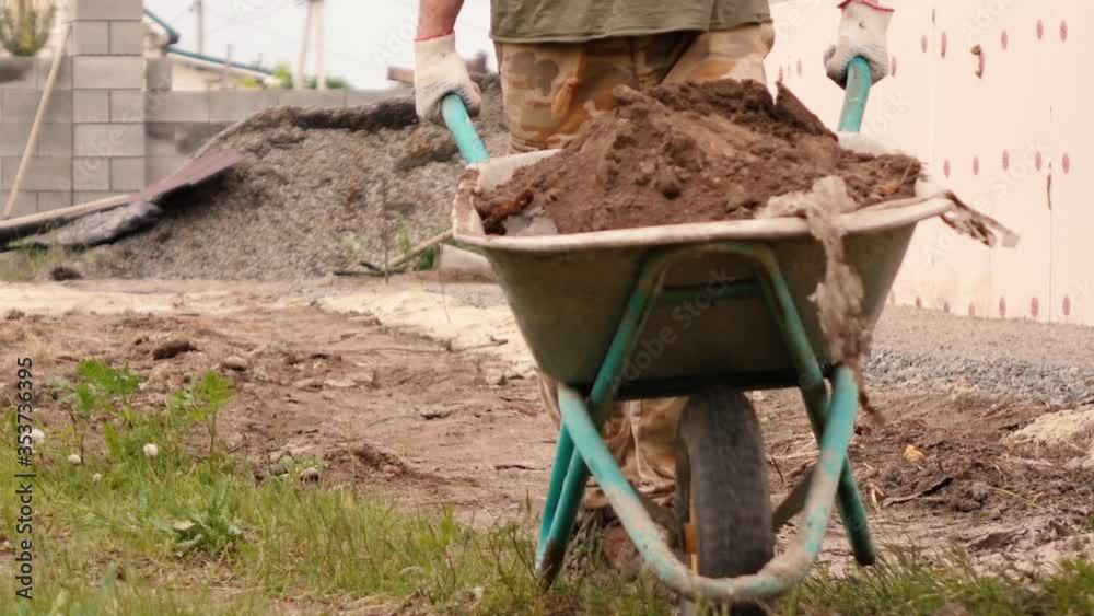 a man rolls a cart full of earth a man rolls a cart full of earth