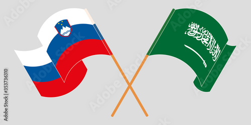 Crossed and waving flags of Slovenia and the Kingdom of Saudi Arabia