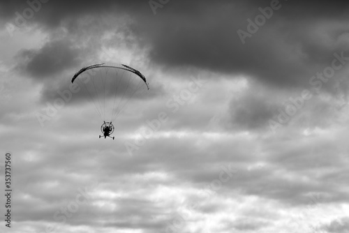 Silhouette of a man on a moto paraglider, motoparaplan, flying in the sky.