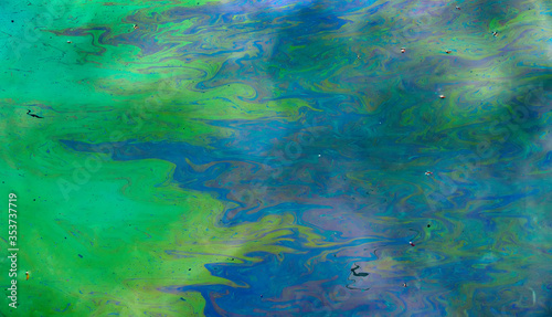 Toxic colours of oil and water in a chemical spill creating a psychedelic blur of rainbow colours. Copyspace area for environmental and pollution based themes and designs.