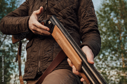 Vintage hunter walks. Rifle Hunter Silhouetted in Beautiful Sunset or Sunrise. Hunter aiming rifle in swamp and field