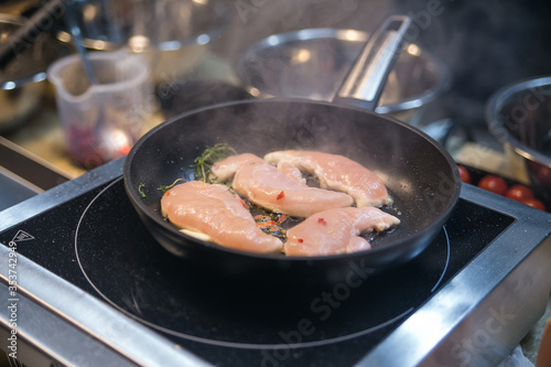 chicken meat is fried in a pan