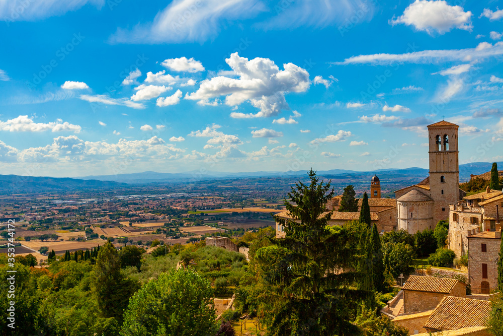 Veduta del paesaggio della piana di Spoleto da Assisi, Umbria, Italia, in una giornata di sole con cielo blu e nuvole bianche