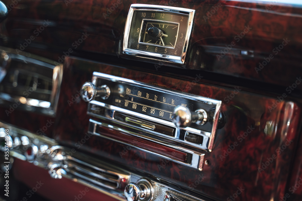 Luxury interior of old classic American car. Wooden decorated dashboard with radio and clocks. Luxury interior of old classic American car. Wooden decorated dashboard with radio and clocks.