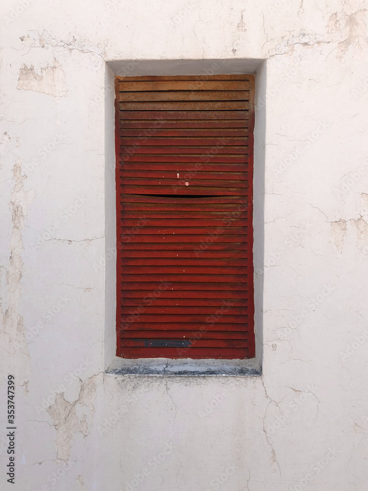 Red shutter on white wall