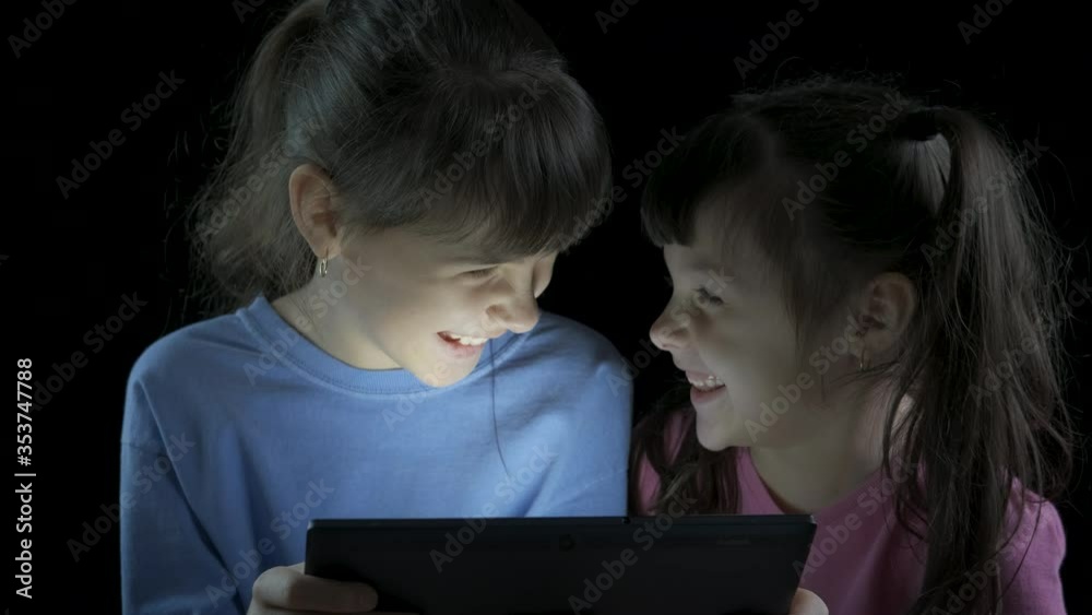 Children on the Internet. Little girls look at the tablet screen and laugh. Children on the Internet. Little girls look at the tablet screen and laugh.