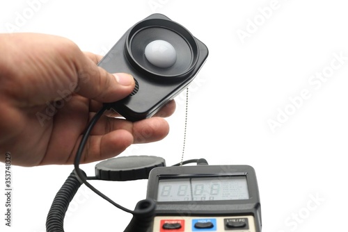 Close up a hand catching a light probe of a LUX meter for measurement. photo