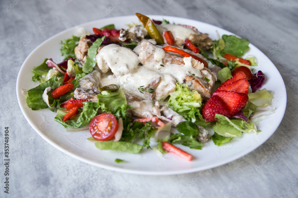 rabbit stewed in a creamy sauce served with vegetables and strawberries rabbit stewed in a creamy sauce served with vegetables and strawberries