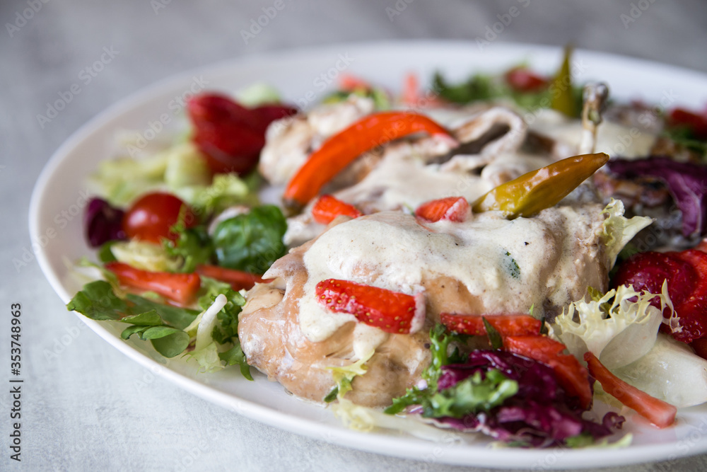 rabbit stewed in a creamy sauce served with vegetables and strawberries rabbit stewed in a creamy sauce served with vegetables and strawberries