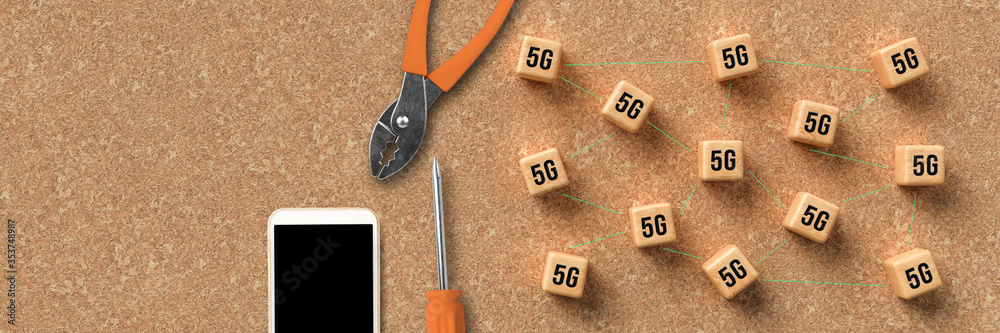 cubes with 5G symbols symbolizing connected network nodes and a smartphone on cork background cubes with 5G symbols symbolizing connected network nodes and a smartphone on cork background