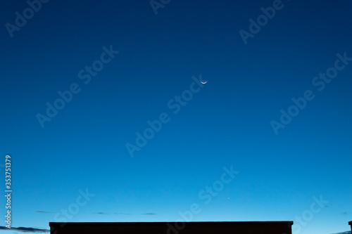 Stunning sunset Waning creacent moon in conjunction with mercury and jupiter Planet at blue hour with no clouds sky. 