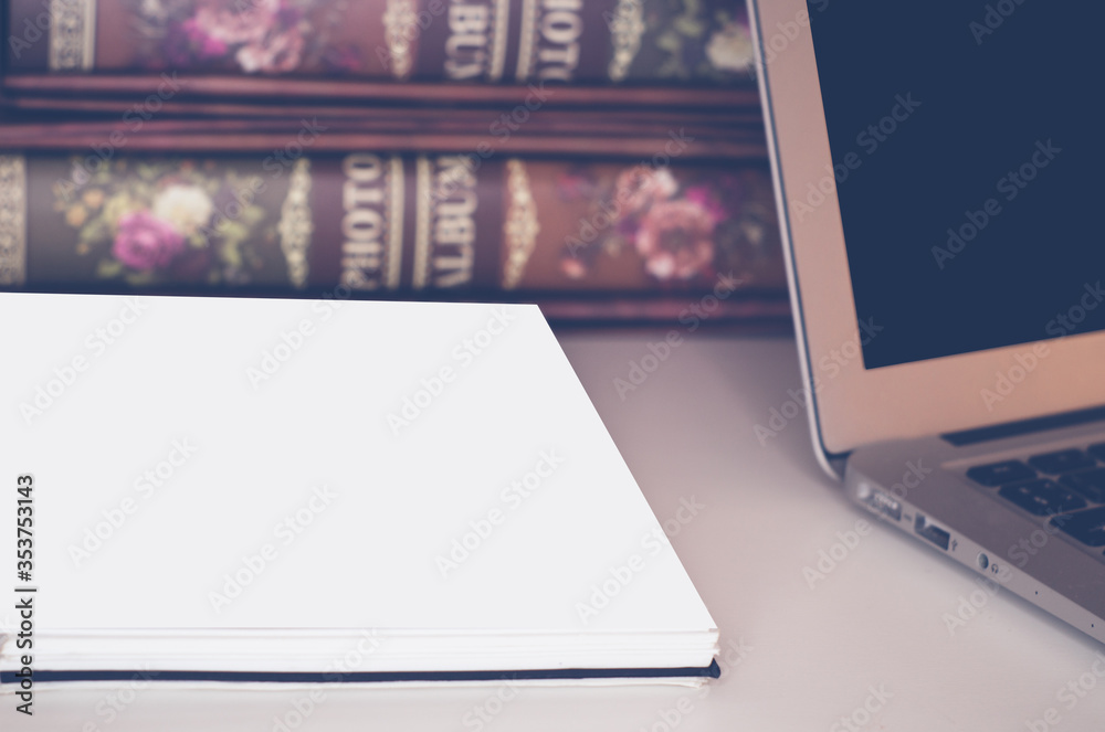 Fototapeta premium Business composition of photo albums on the table with a laptop and notepad