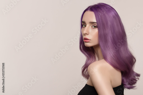 portrait of a woman with luxurious lilac hair on a gray background. Bright hair