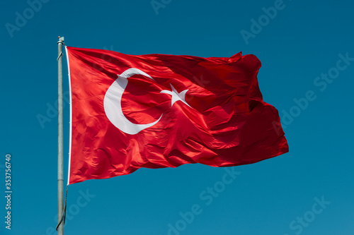 Valokuva Turkish flag waving in blue sky.