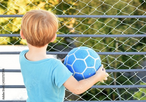 Two years old blond boy playing at the terrace during quarantine for coronavirus. There is a security net on the balcony. 21st March, 2020, Buenos Aires, Argentina.