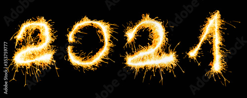 Year 2021 number written in sparklers on a black background. New Year concept.