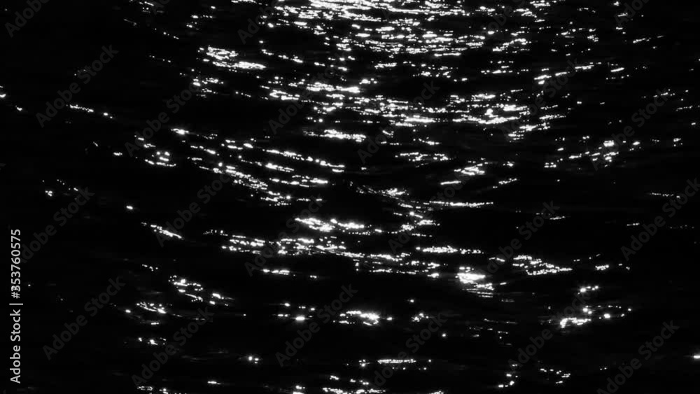 Light reflecting off of water. Sunset shimmering on black water 
