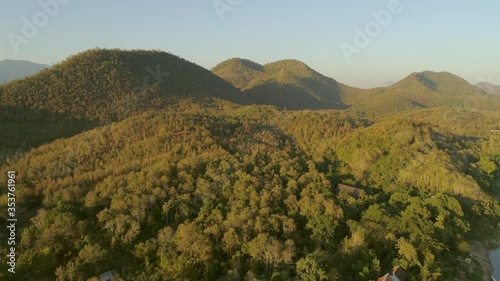 Aerial shot of green forest against clear sky, drone is flying over trees - Luang Prabang, Laos photo