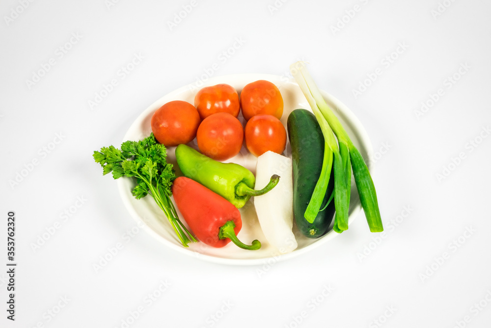 Vegetables isolated on a white background on the white plate ready for cooking.