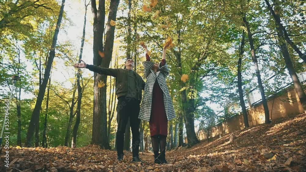 Couple is throwing up maple leaves in the autumn park. 4K. Couple is throwing up maple leaves in the autumn park. 4K.