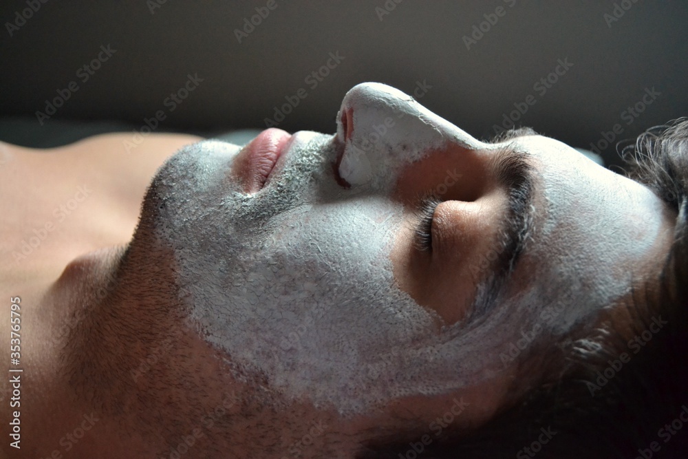 Naklejka premium Man relaxing during facial at spa