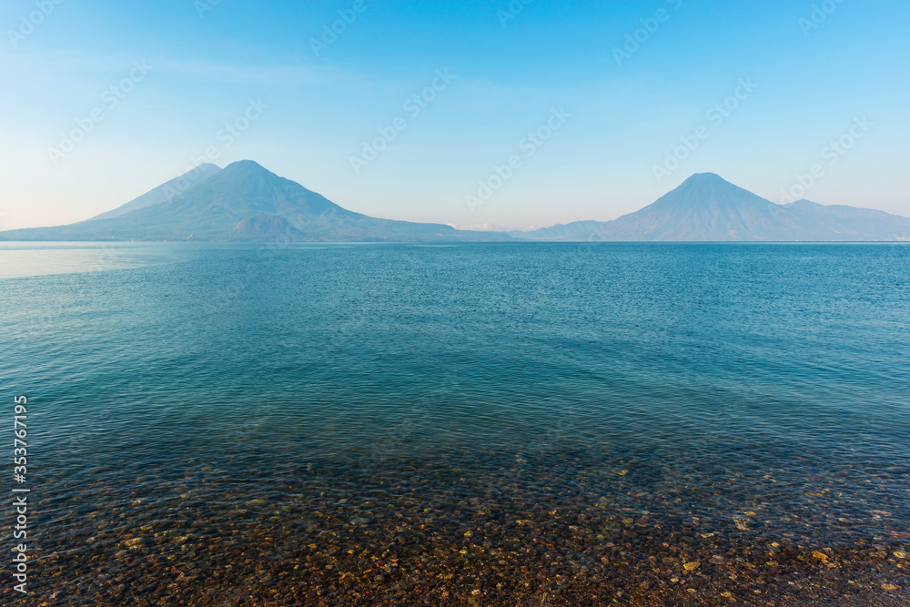 The Atitlan, Toliman and San Pedro Volcano at sunrise by the shore of the Atitlan Lake, Panajachel, Guatemala.