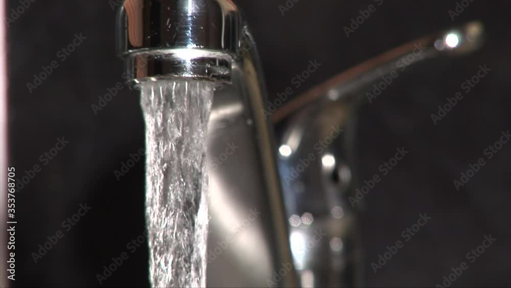 Kitchen faucet tap close up with fresh water pouring out Kitchen faucet tap close up with fresh water pouring out