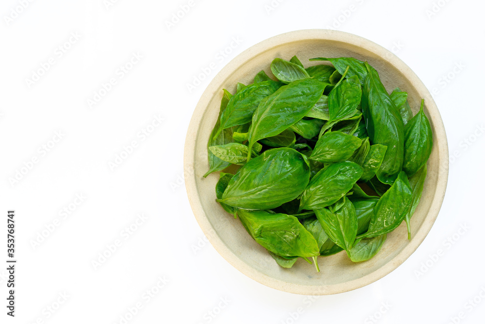 Bowl of basil leaves on white background. Bowl of basil leaves on white background.
