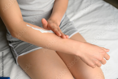 Cropped shot of woman applying moisturizer skin cream on her hand. Skin care is product for support skin or enhance its appearance.