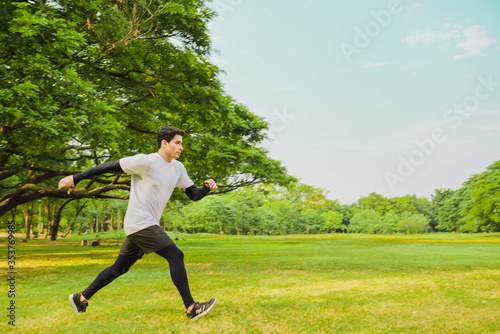 Young man running in the green park