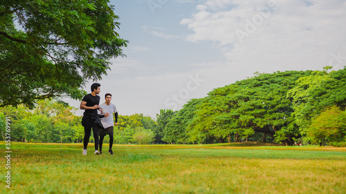 Sportman running in the green park with friend © calcassa