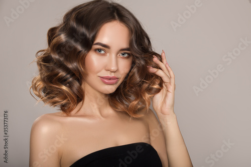 Portrait of a woman with curly hair. Haircut. Shine and hair care