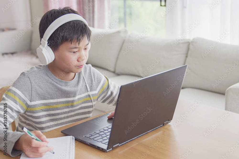 Preteen tween teen boy making facetime video calling with laptop at home, using zoom online class meeting app, social distancing,homeschooling,learning remotely , new normal concept Preteen tween teen boy making facetime video calling with laptop at home, using zoom online class meeting app, social distancing,homeschooling,learning remotely , new normal concept