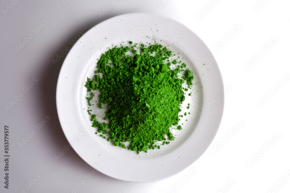 Heap of powdered matcha tea in a plate on a white background. Top view. Heap of powdered matcha tea in a plate on a white background. Top view.