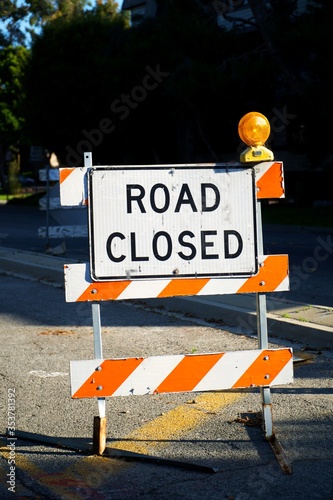 фотографія A road closed temporary sign displayed in the middle of the street during sewer
