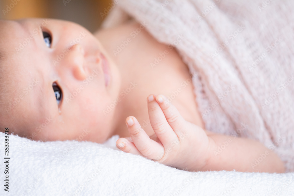 Selective focus tiny finger hand of newborn baby movement using small muscle, infant open her eyes looking for mother with curiosity cannot see anything, toddler lie down on bed at home or hospital Selective focus tiny finger hand of newborn baby movement using small muscle, infant open her eyes looking for mother with curiosity cannot see anything, toddler lie down on bed at home or hospital