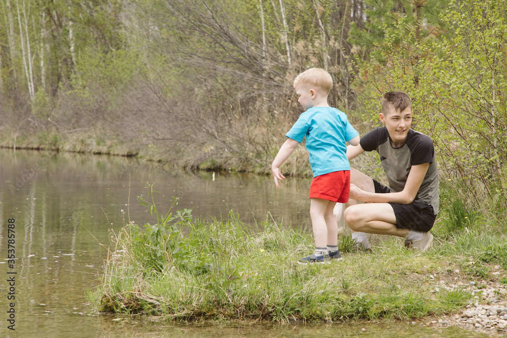 Children on a river in a forest catch fish Children on a river in a forest catch fish